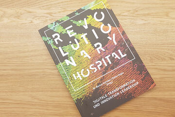 Agentur lege artis - Das Buch "Revolutionary Hospital" liegt auf einem Tisch